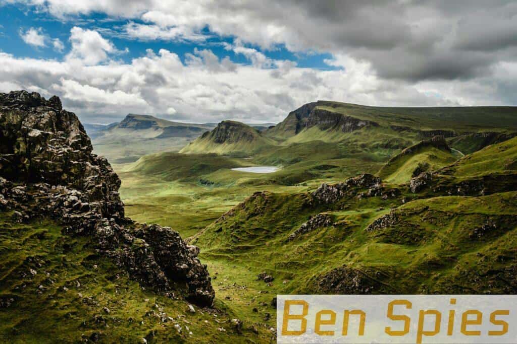 green grass on mountain under white cloudy sky